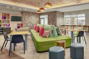 科罗拉多斯普林斯Home2 Suites By Hilton Colorado Springs South, Co的客厅配有带色彩缤纷枕头的绿色沙发