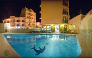 圣安东尼奥阿德林诺旅馆的一座游泳池,在晚上在建筑物前