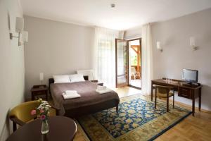波兰尼卡-兹德鲁伊薇拉扎梅泽科酒店的一间卧室配有一张床、一张书桌和一台电视