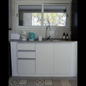 奇基塔湖巴尔内阿里奥COMPLEJO LA ISLA MAR CHIQUITA的白色的厨房设有水槽和窗户