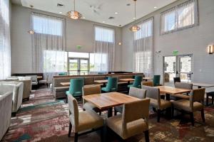 盐湖城Homewood Suites By Hilton Salt Lake City Airport的用餐室设有桌椅和窗户。
