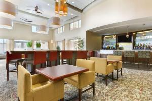 月球乡匹兹堡机场/罗宾逊广场区希尔顿霍姆伍德套房酒店的一间带桌椅的餐厅和一间酒吧