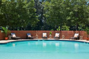 亚特兰大亚特兰大-佩米特/邓伍迪假日酒店的一个带椅子的游泳池,砖墙