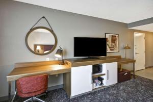 哥伦布哥伦布伊斯顿区汉普顿套房旅馆的客房设有一张带电视和镜子的书桌