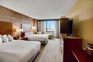 休斯顿DoubleTree by Hilton Hotel & Suites Houston by the Galleria的酒店客房设有两张床和一台平面电视。