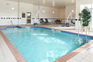 奥克代尔Hilton Garden Inn St. Paul Oakdale的蓝色的大游泳池,位于酒店客房内