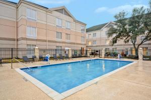 圆石城Hilton Garden Inn Austin Round Rock的大楼前的游泳池