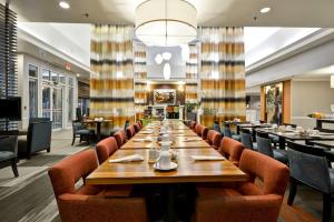 圆石城Hilton Garden Inn Austin Round Rock的大型用餐室配有长桌和椅子