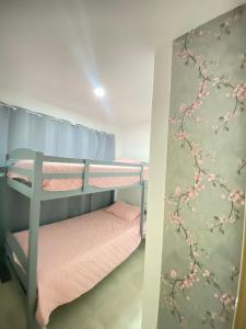 圣萨尔瓦多Paradise Apartment的卧室配有两张双层床,墙上挂着鲜花