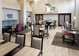韦斯特福德韦斯特福德-切姆斯福德汉普顿套房酒店的一间带桌椅的餐厅和一间用餐室