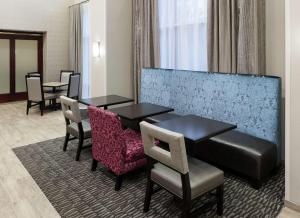 韦斯特福德韦斯特福德-切姆斯福德汉普顿套房酒店的酒店客房带两张桌子和椅子