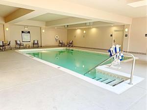 乌尔班纳尚佩恩/厄巴纳希尔顿恒庭酒店的游泳池位于酒店客房内,配有桌椅