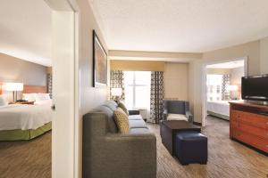 奥兰多奥兰多国际大道/会展中心希尔顿惠庭套房酒店的酒店客房设有沙发、床和电视。