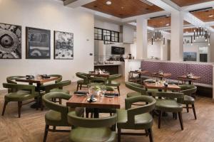 孟菲斯Hilton Garden Inn Memphis Downtown Beale Street的餐厅设有木桌和绿色椅子