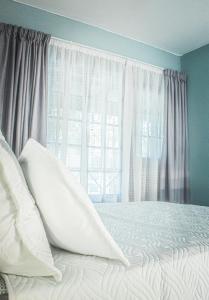 贝拉贝拉19 @ Pendleberry的卧室配有带白色枕头的床和窗户。