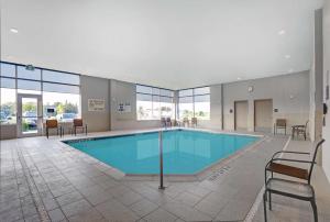 贝尔维尔Hampton Inn & Suites Belleville的一座带桌椅的游泳池