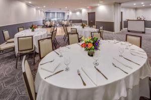 伊丽莎白希尔顿纽华克机场酒店的宴会厅配有白色的桌椅和鲜花