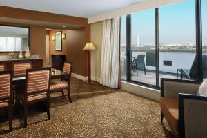 阿林顿华盛顿特区水晶城希尔顿逸林酒店的酒店客房设有桌椅和大窗户。