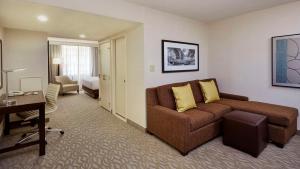 阿林顿华盛顿特区水晶城希尔顿逸林酒店的一间客厅,客厅配有沙发和一张书桌,位于酒店的房间