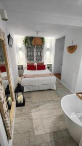 蒙特哈克La Damajuana, Casa Rural的一间白色卧室,配有一张床和浴缸