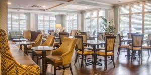 查尔斯顿查尔斯顿-丹尼尔岛汉普顿酒店的餐厅设有桌椅和窗户。