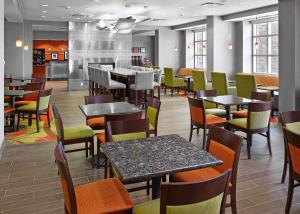 卡尔加里汉普顿希尔顿卡尔加里机场北酒店的一间带桌椅的餐厅和一间酒吧