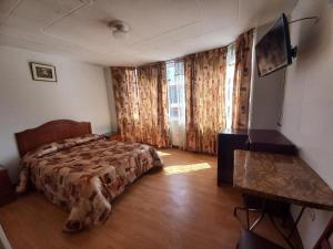 普诺HOSTAL SUMITA HOUSE_INN的一间卧室配有一张床和一张书桌