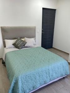 蒙特雷Casa Nórdica - Monterrey的一间卧室配有一张带绿色棉被的大床