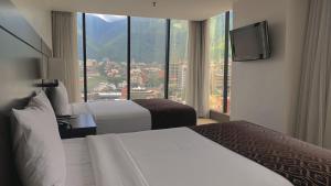 加拉加斯HOTEL CHACAO SUITES的酒店客房设有两张床和一台平面电视。