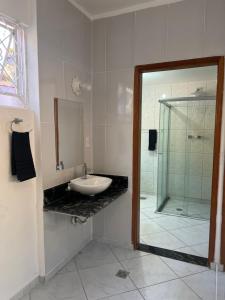 帕萨夸特鲁Hostel Passa4的一间带水槽和玻璃淋浴的浴室