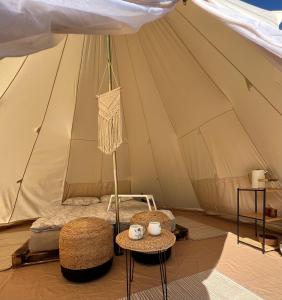 鲁斯内Glamping Rusne的帐篷内的一张床位,配有两把椅子和一张桌子