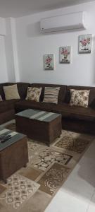 Al Ḩammādحجز شاليهات مارينا دلتا ومارينا لاجونز的客厅配有棕色沙发和桌子