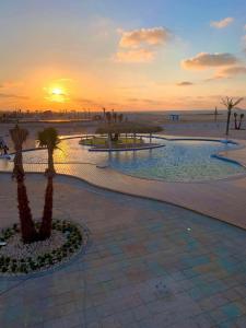 Al Ḩammādحجز شاليهات مارينا دلتا ومارينا لاجونز的棕榈树和日落海滩的度假村