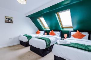Robin HoodLuxury Large Leeds 10bed 2.5bath Modern House Free Parking的配有绿色墙壁和橙色枕头的三张床