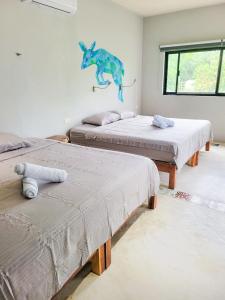 图卢姆Maui Hostels Tulum的墙上有恐龙的房间,有三张床