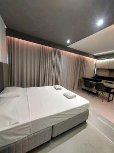 大坎普Estúdio Moderno e Elegante no Vertigo的卧室配有白色大床和钢琴