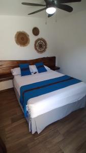 康塞普西翁德阿塔科Hotel María Isabel Ataco的卧室配有带蓝色枕头的大型白色床