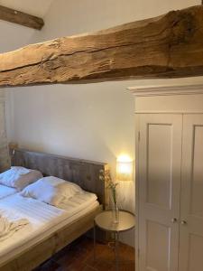 BrassyRuime woning in de Morvan, Bourgogne met seizoensgebonden zwembad的一间卧室配有一张木梁上方的床。