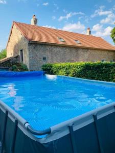 BrassyRuime woning in de Morvan, Bourgogne met seizoensgebonden zwembad的一座大蓝色游泳池,位于房子前