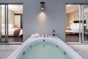 墨西哥城Suites Giorgio的带浴缸的客房,设有两张床