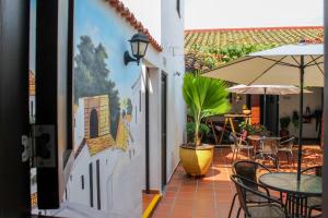 希龙Hotel Colonial San Felipe的一个带桌椅和遮阳伞的庭院