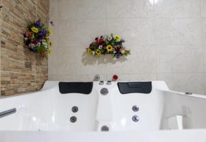 希龙Hotel Colonial San Felipe的浴室配有带鲜花的浴缸。