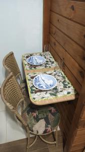 布卢梅瑙Suíte privativa 11km vila germânica的一张桌子,两把椅子,一张桌子,上面有盘子