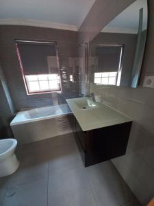 瓜尔达TORREÃO HOUSE的一间带水槽、浴缸和镜子的浴室