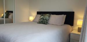 芒格努伊山中庭公寓式酒店的卧室配有白色的床和2个枕头