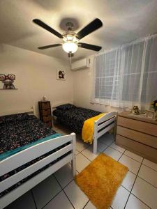 Cozy in Cabo1的一间卧室配有两张床和吊扇