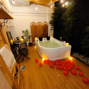 达沃市Stellar Homesharing (Home #2)的浴缸位于木地板上,周围是樱桃