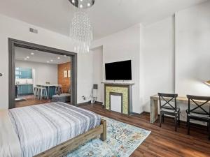 匹兹堡Luxury and Stylish 2Bedroom Apartment on Carson, South Flats, Pittsburgh的一间卧室配有一张床、一个壁炉和一台电视。