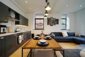 利兹Stylish & Elegant city centre apartment的厨房以及带桌子和沙发的客厅。