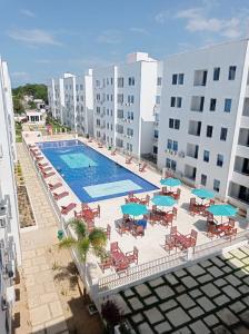 科韦尼亚斯Cómodo apartamento cerca al mar的享有带椅子和遮阳伞的游泳池的上方景色